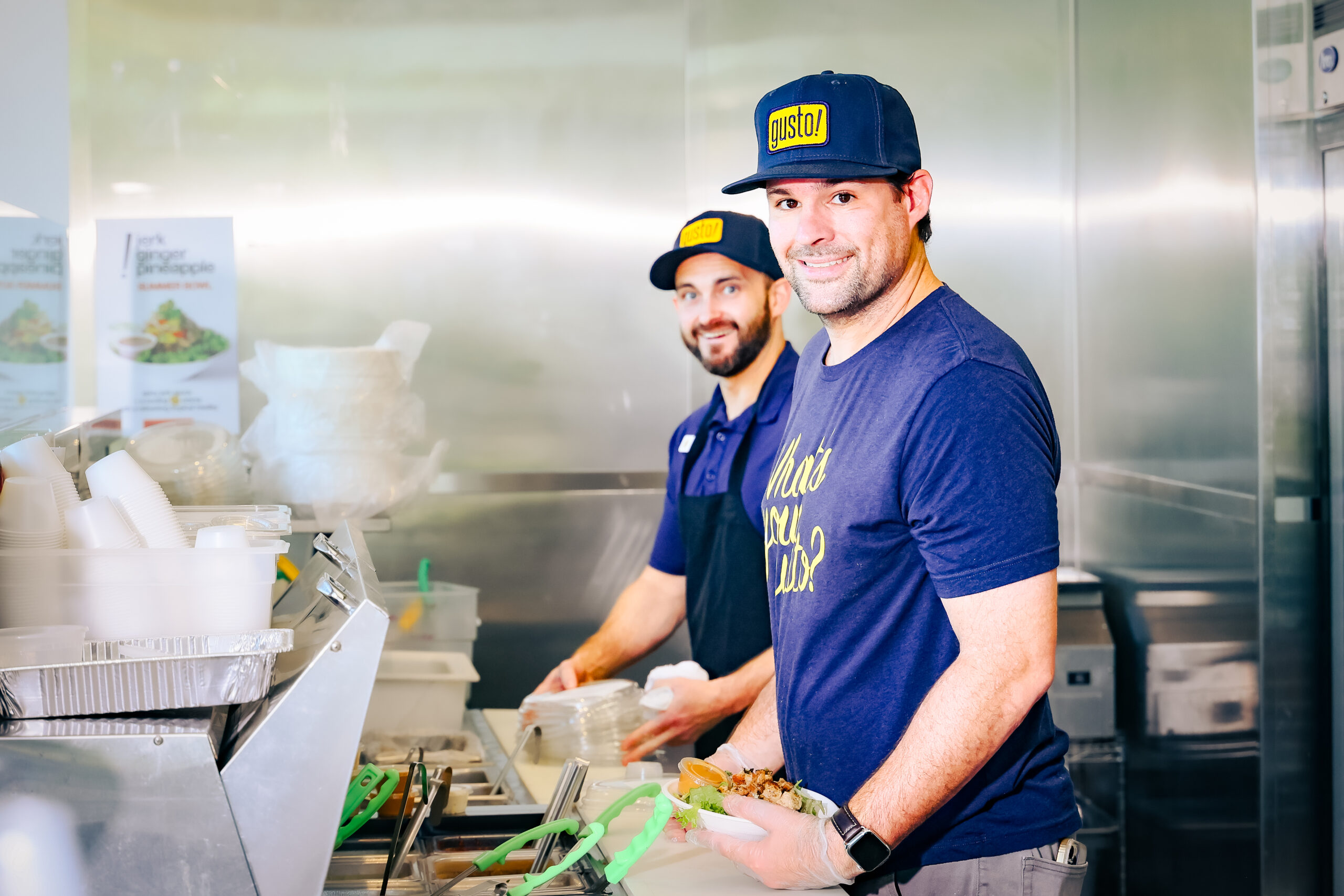 Back of house cooks at gusto! preparing a salad while smiling